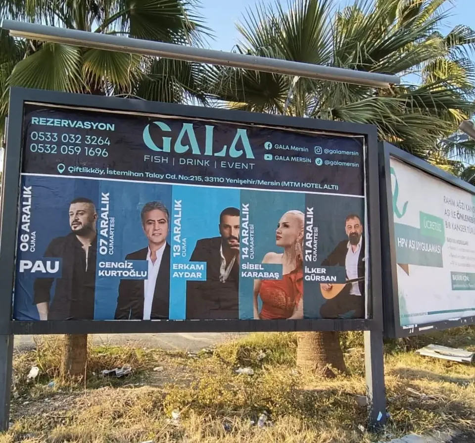 Yol kenarındaki ilan panosuna asılmış etkinlik duyuru afişi.